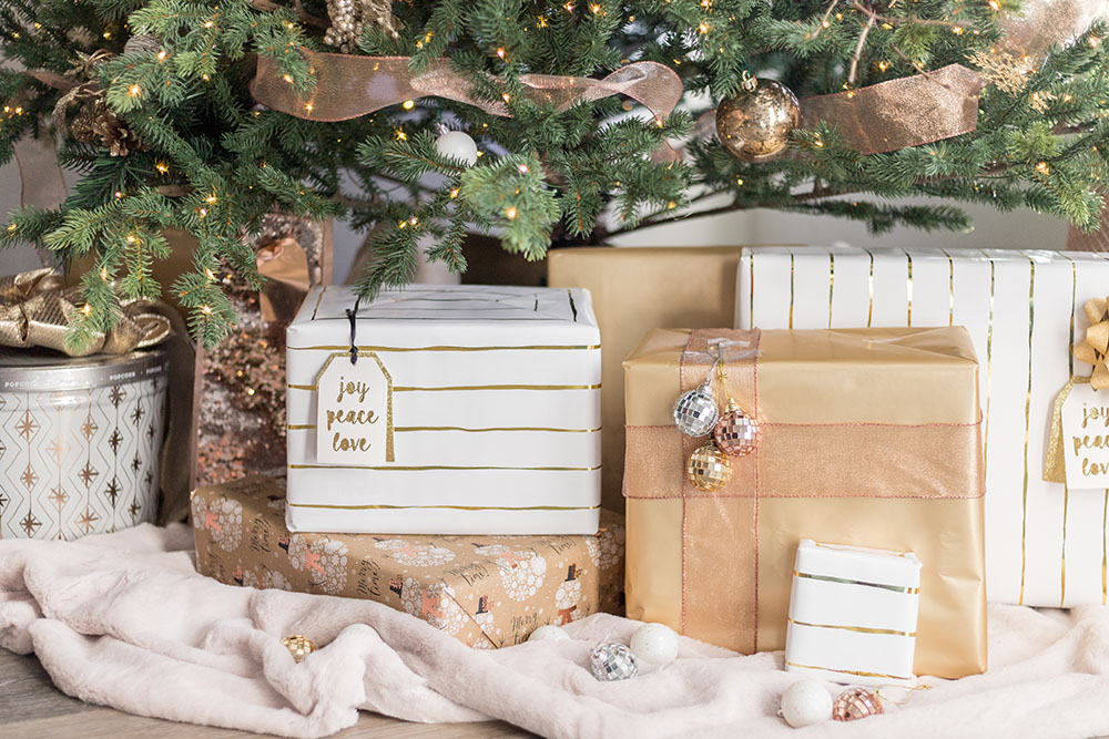 A group of presents wrapped in white, gold, silver, and copper.