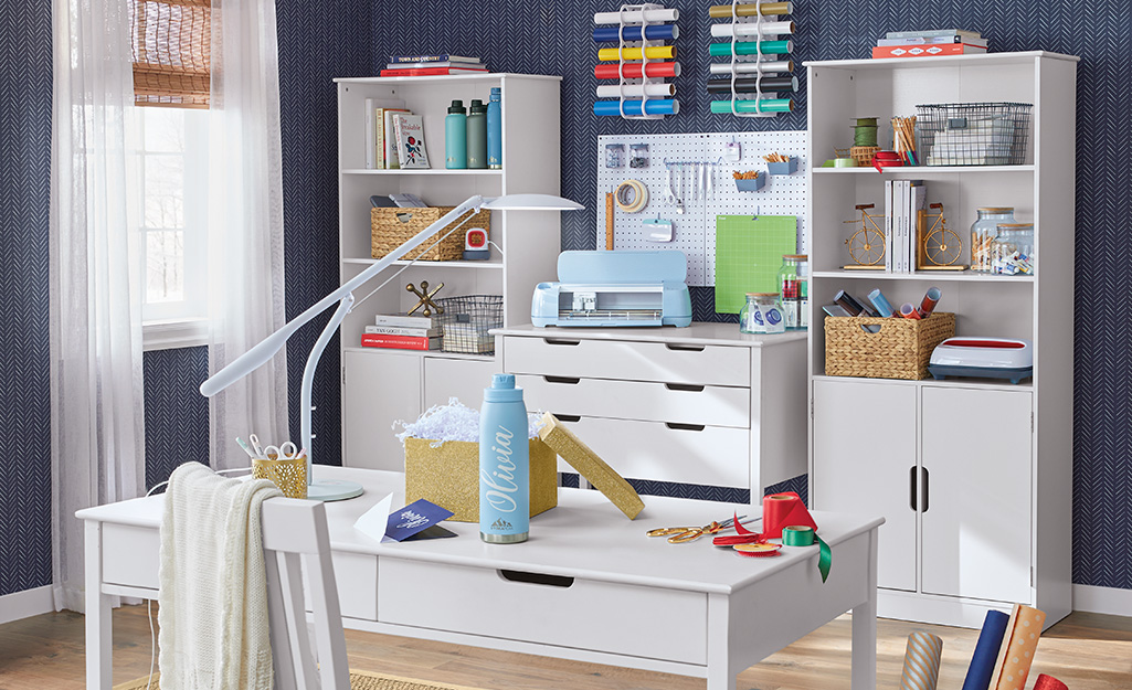 Super organized craft room with desk, cabinet and bookcases