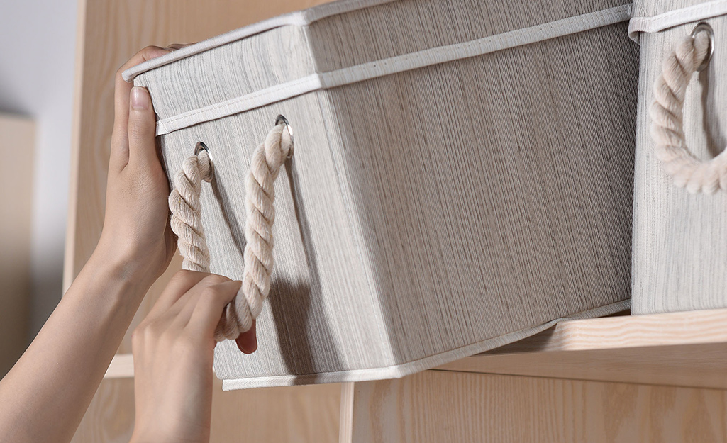 Storage bins with handles on a bookshelf