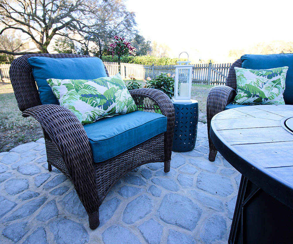 A tropical outdoor throw pillow decorates a patio chair. A tropical outdoor throw pillow decorates a patio chair.