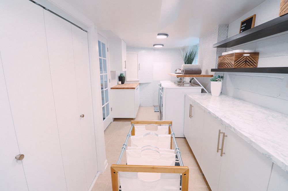 A large laundry room with multiple areas of counter space.