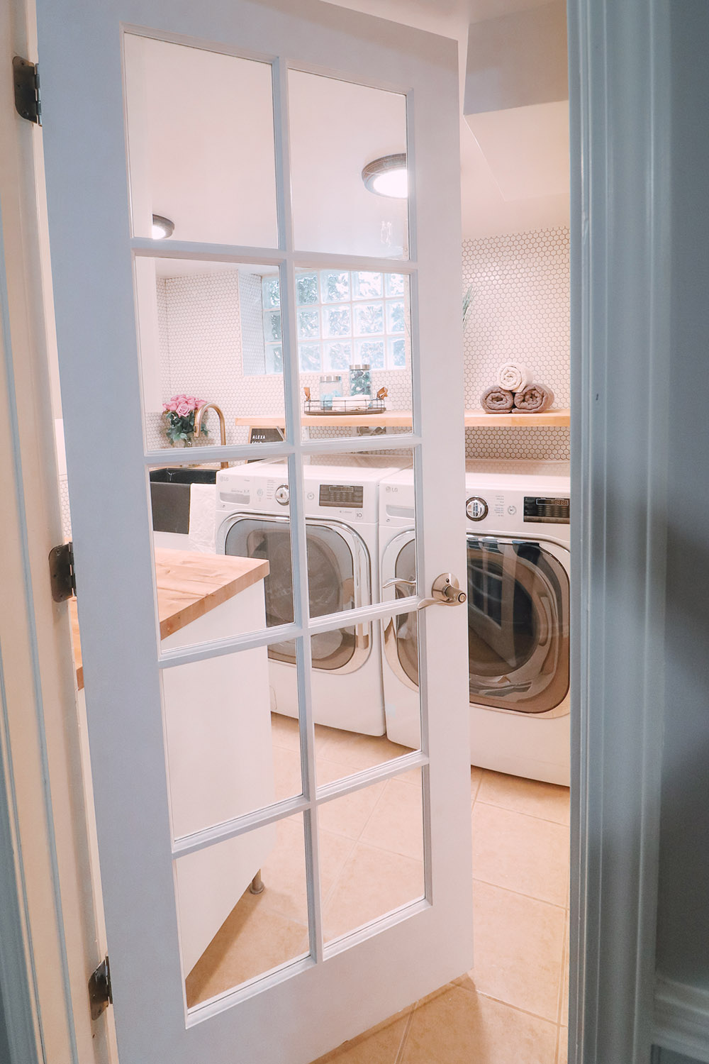 A white shaker door with glass opening into a laundry room.