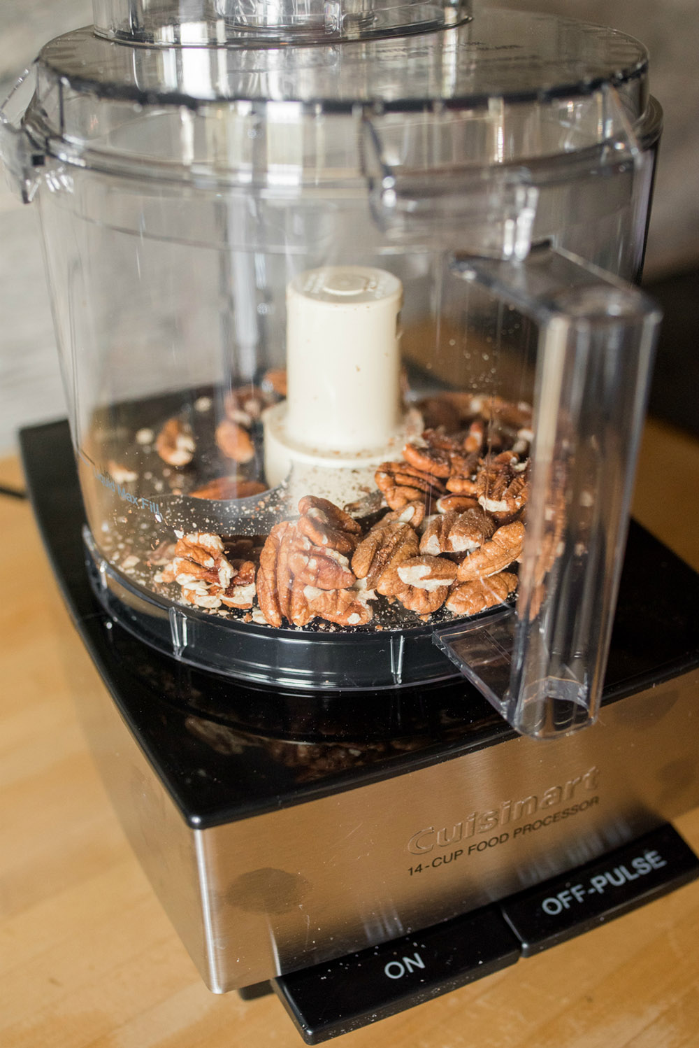 Pecans in a stainless steel Cuisinart food processor.