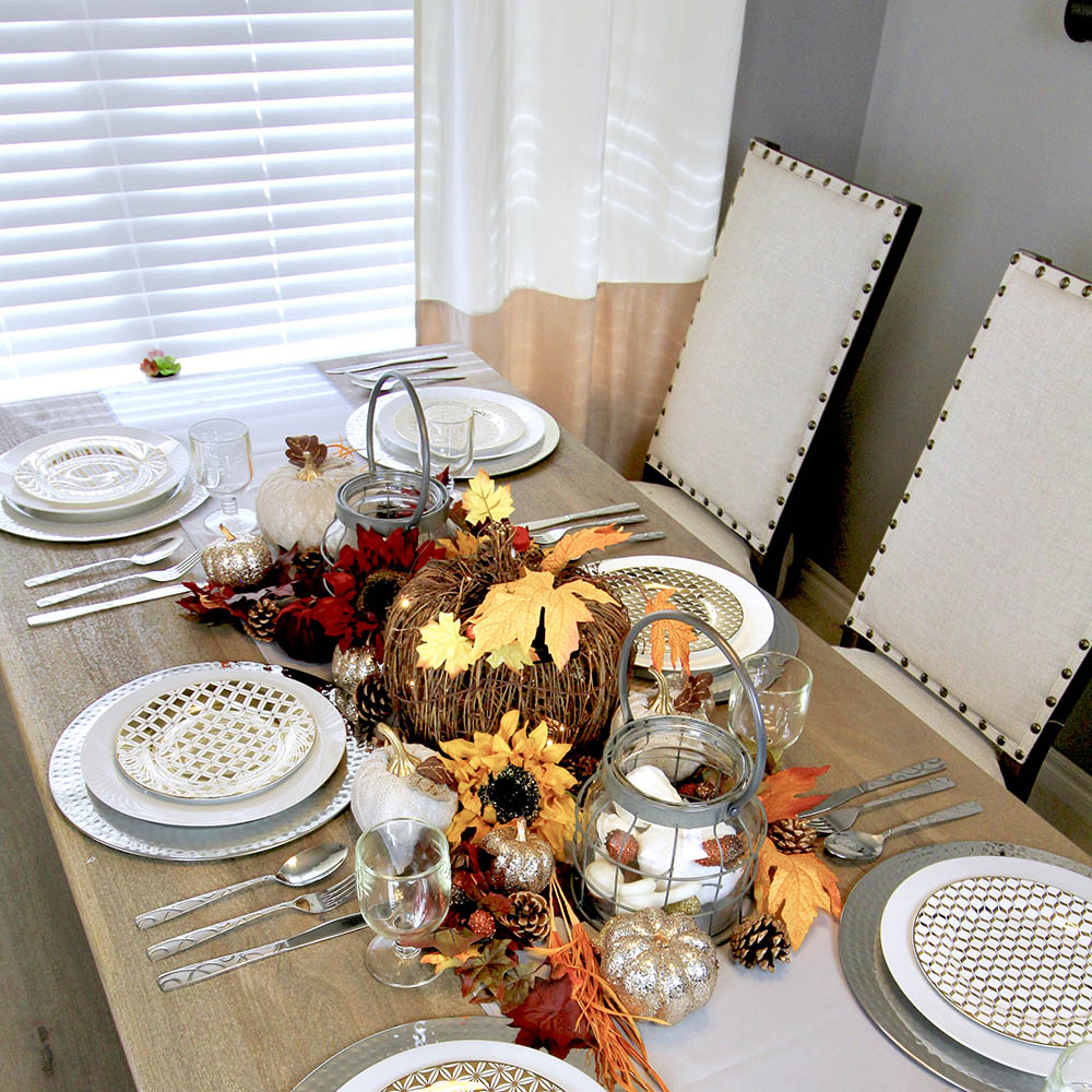 A wooden dining table decorated with Fall colors for Friendsgiving.