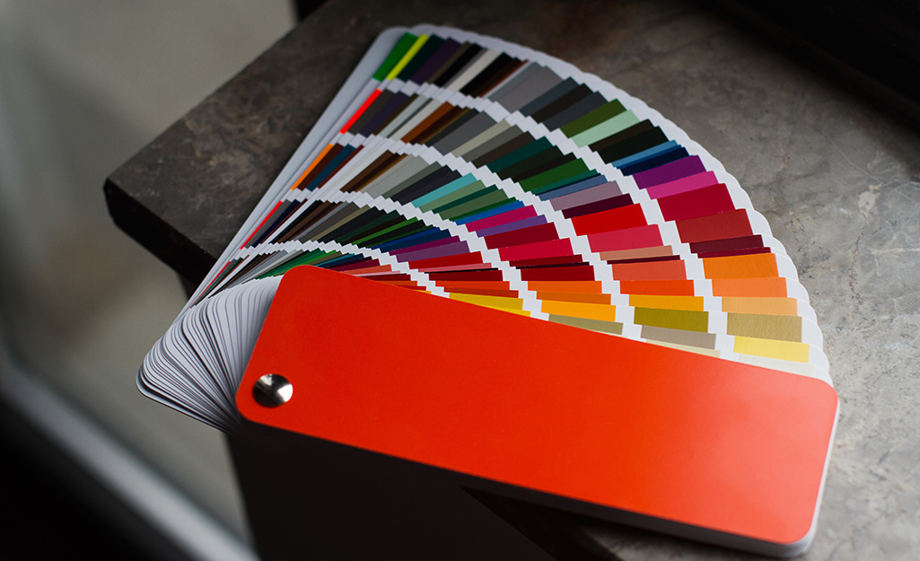 Paint swatches lay fanned out of a gray surface.