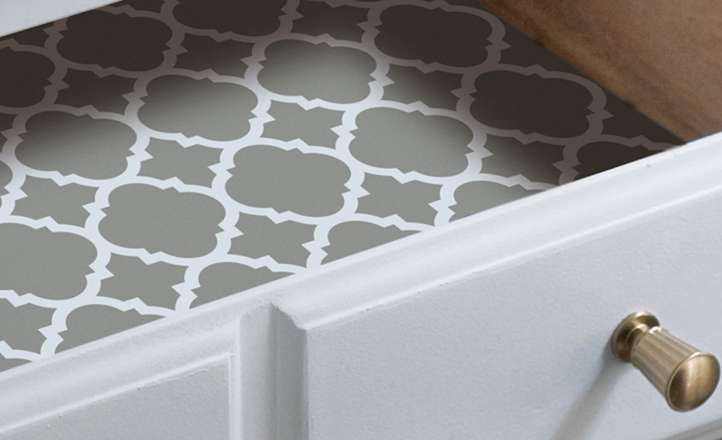 Contact paper with a gray-and-white pattern lines an open drawer.