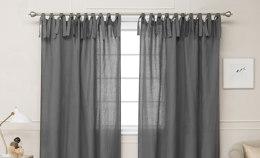 Gray tie top curtains over a window.