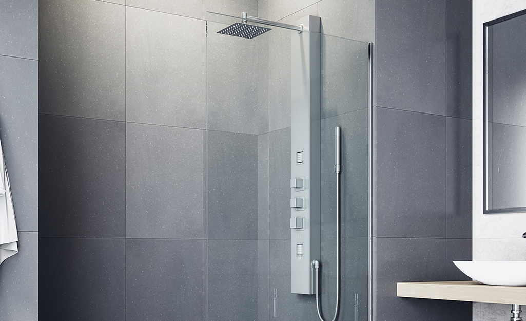A shower tower in a shower with a glass door.