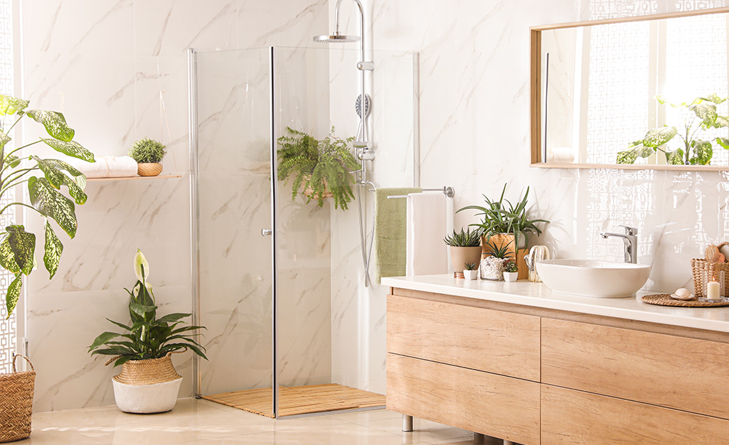A neutral bathroom with plants scattered around.