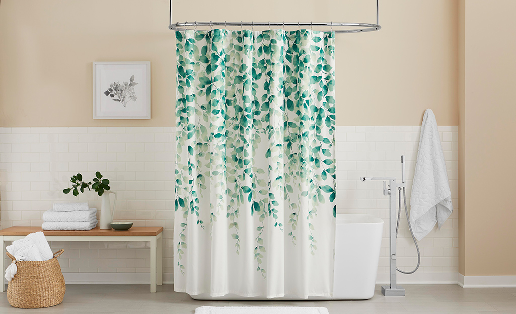 Bathroom with a tub shower and a green and white shower curtain.