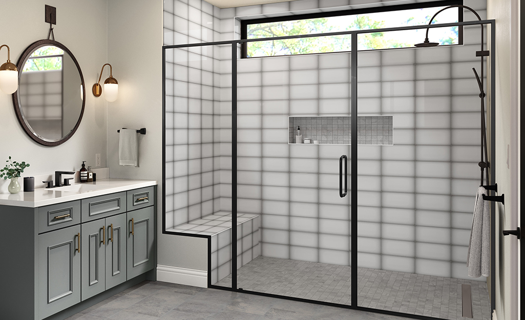 A walk-in shower with a glass door with black trim.