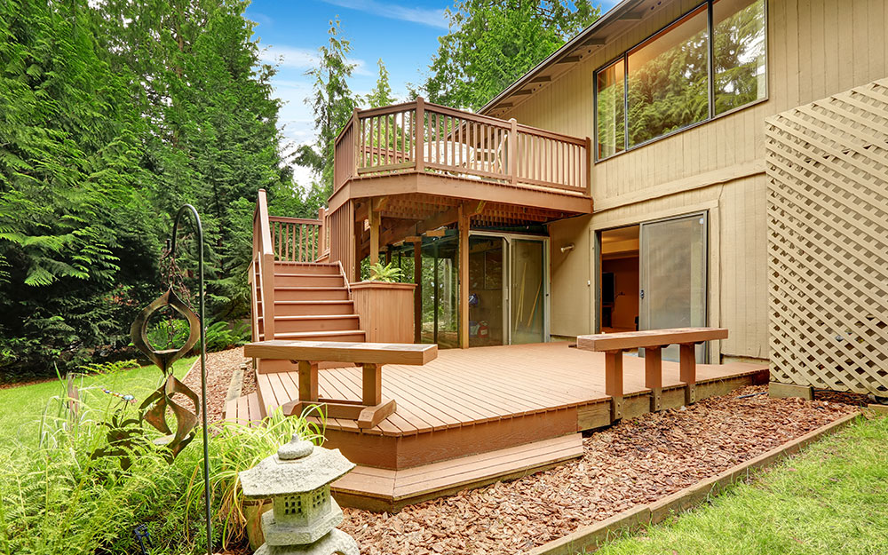 A multilevel deck includes matching bench seating and a staircase leading to the upper level.