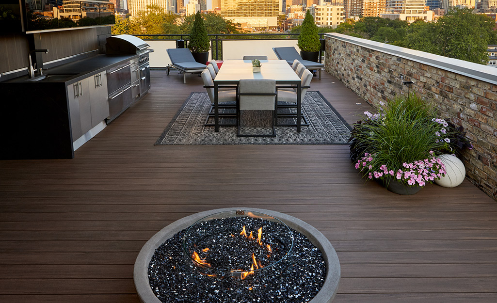 A deck with outdoor kitchen and fire pit