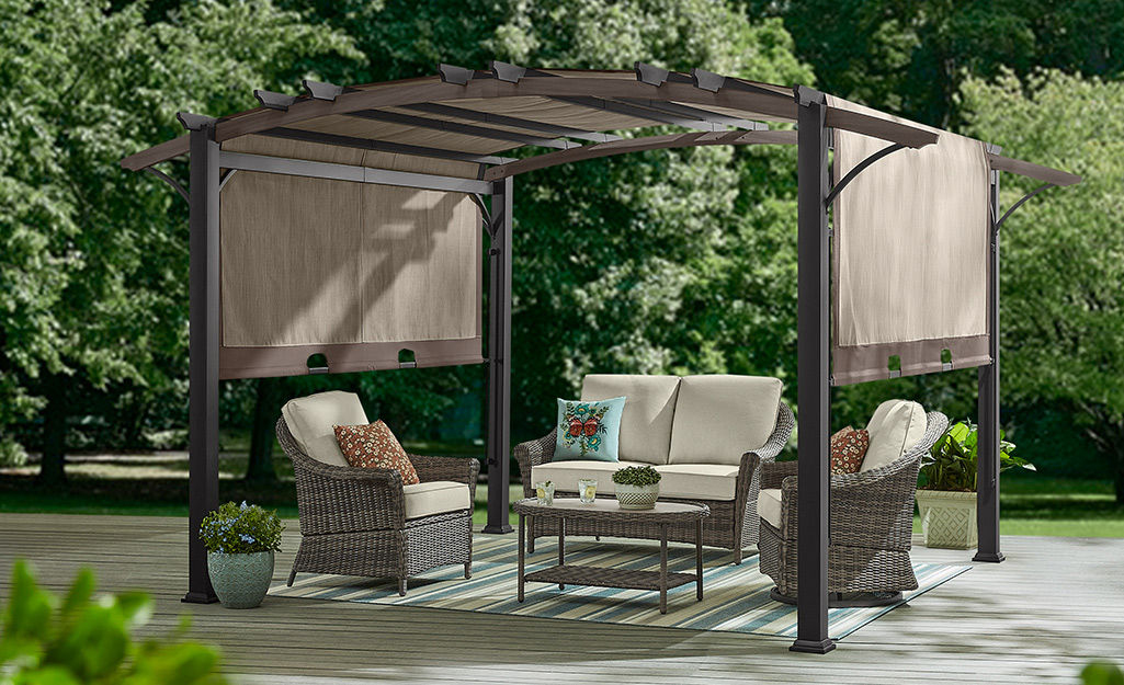 A pergola with a shade over a patio.