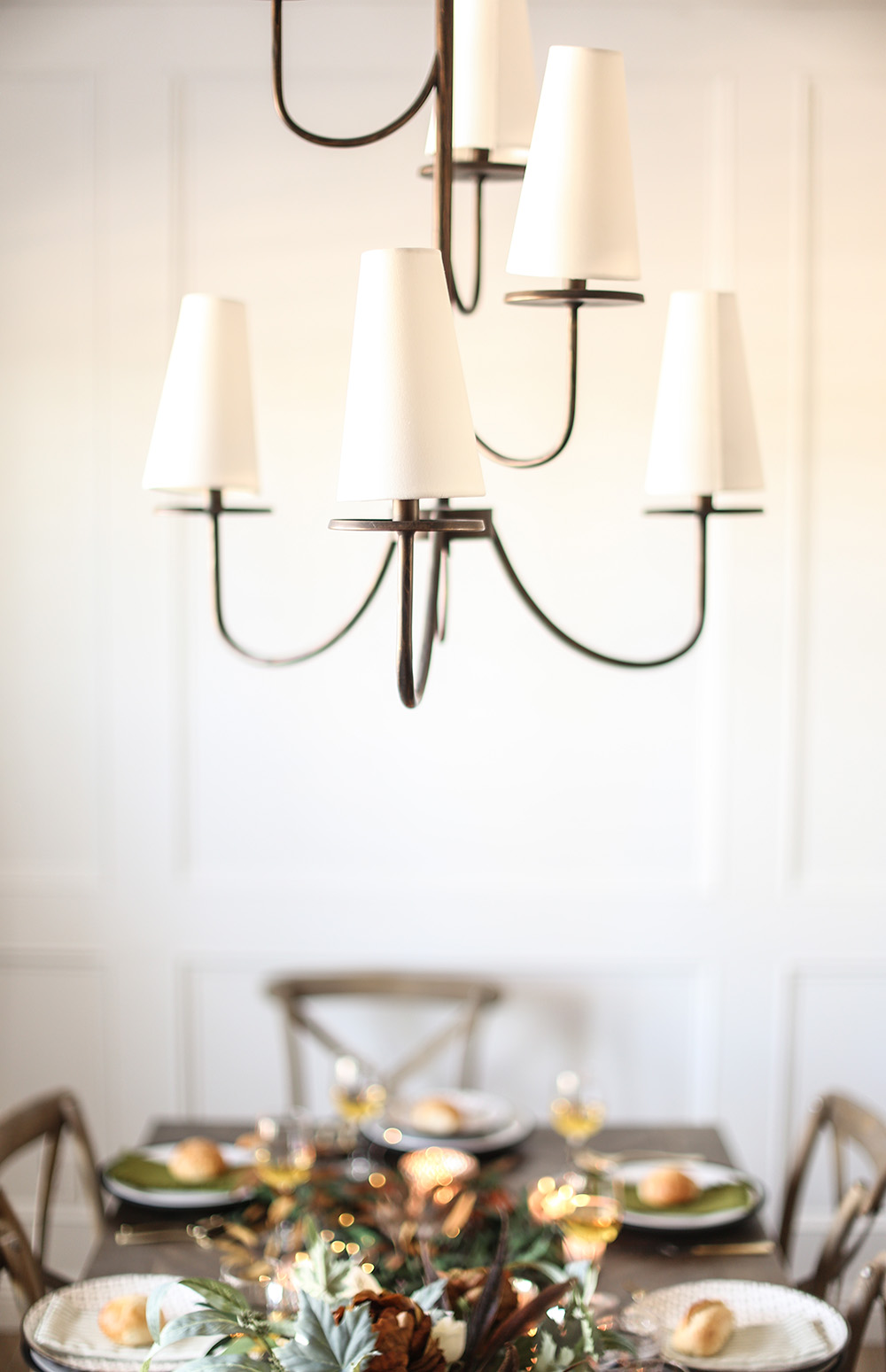 A chandelier hangs over a dining room table decorated for the holidays. A chandelier hangs over a dining room table decorated for the holidays.