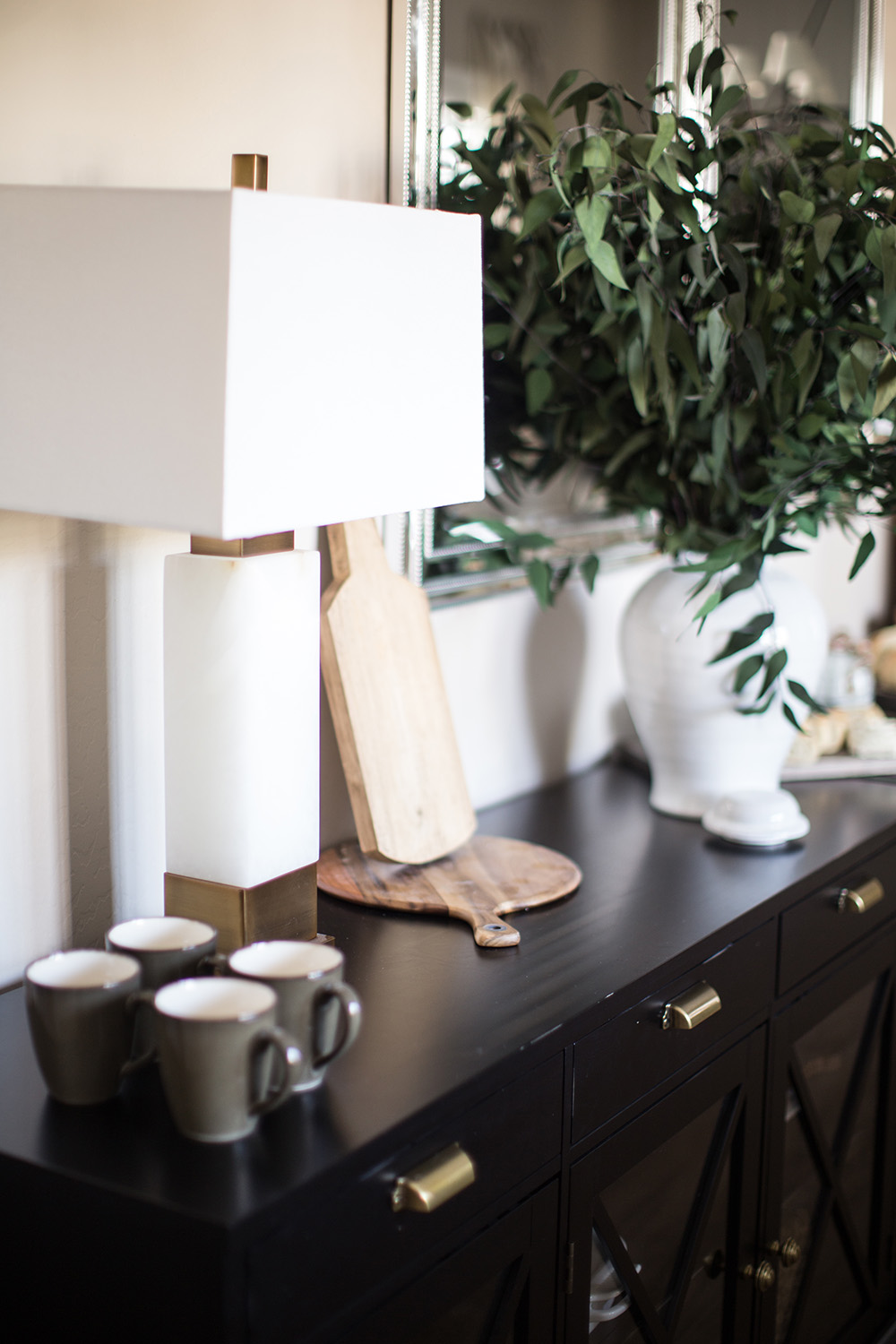 Two gold and marble lamps decorate a black buffet. Two gold and marble lamps decorate a black buffet.