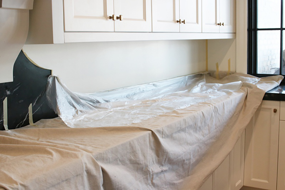 A kitchen countertop covered in drop cloths.