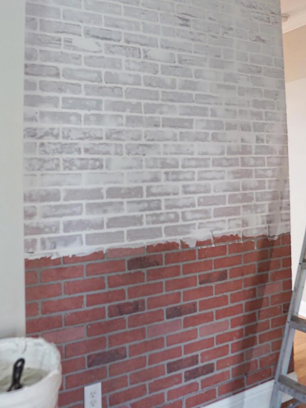 A partially faux whitewashed brick accent wall.