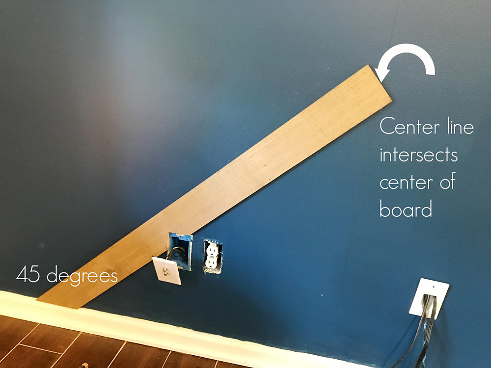 A piece of weathered wood board attached to a dark painted accent wall. A piece of weathered wood board attached to a dark painted accent wall.