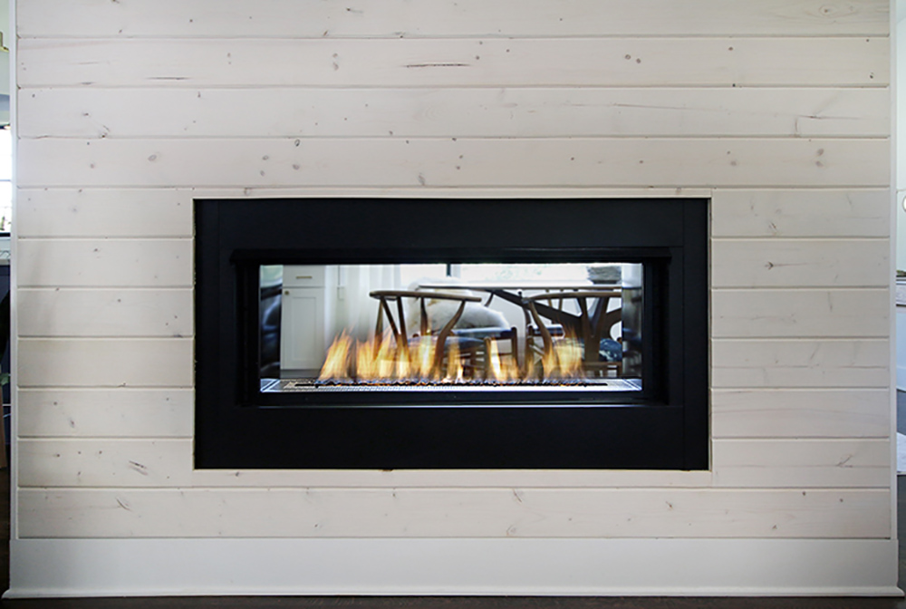 A burning modern fireplace surrounded by shiplap. A burning modern fireplace surrounded by shiplap.