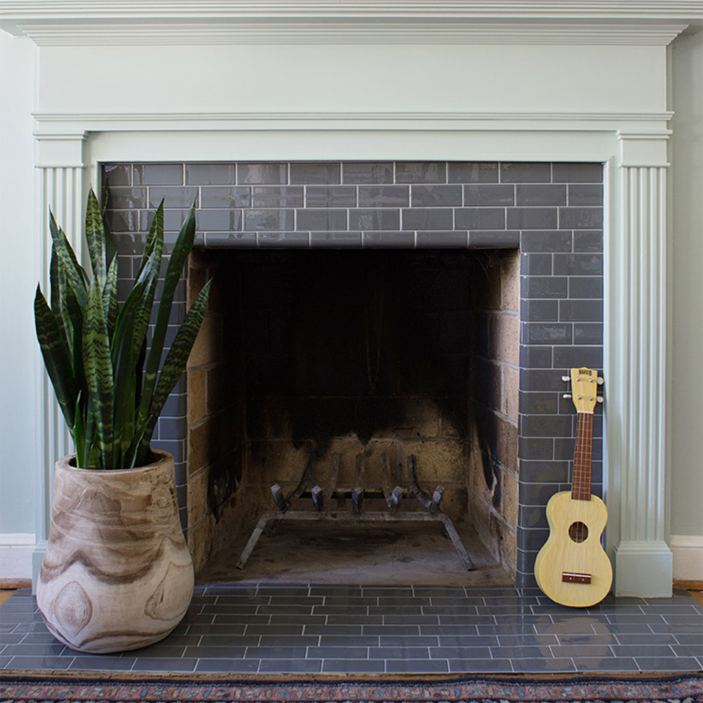 A DIY tile fireplace makeover with gray peel and stick tile.