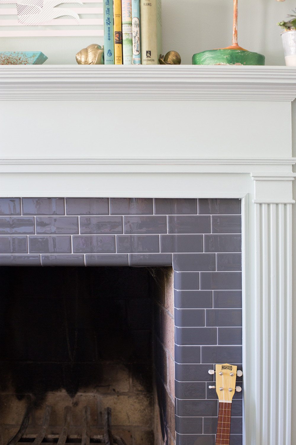 A DIY tile fireplace makeover using gray Smart Tiles.