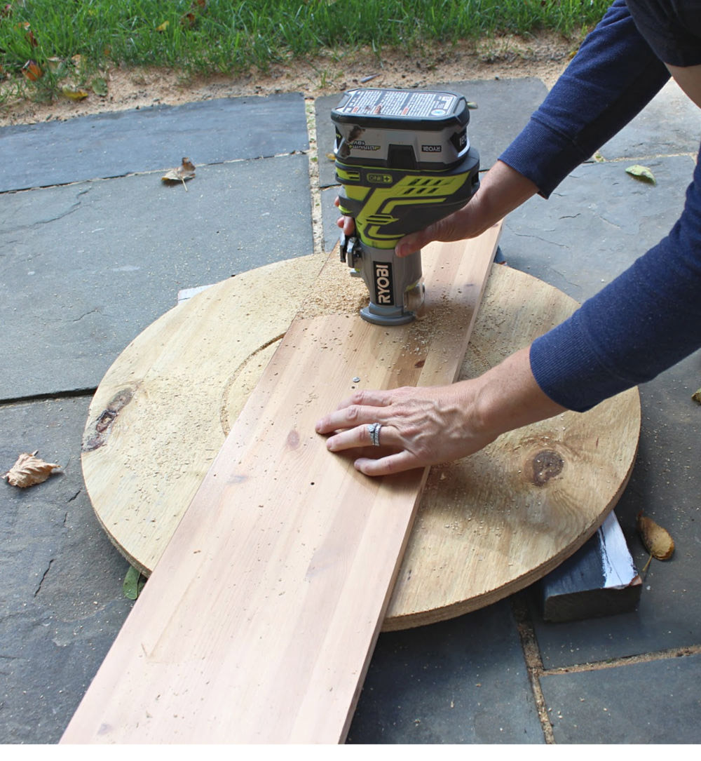 A person using a router on a piece of plywood.