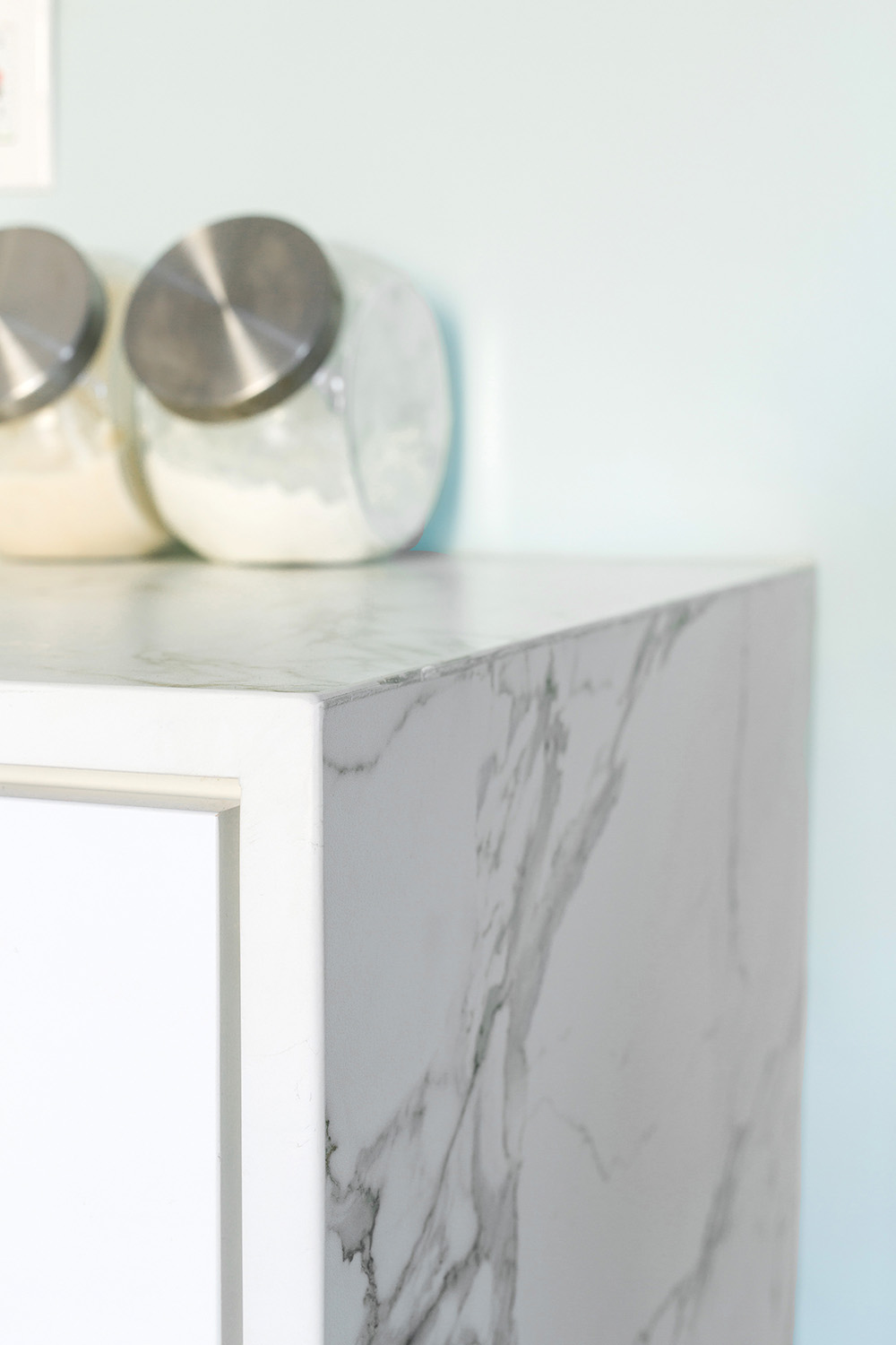 A marble counter top with glass containers.