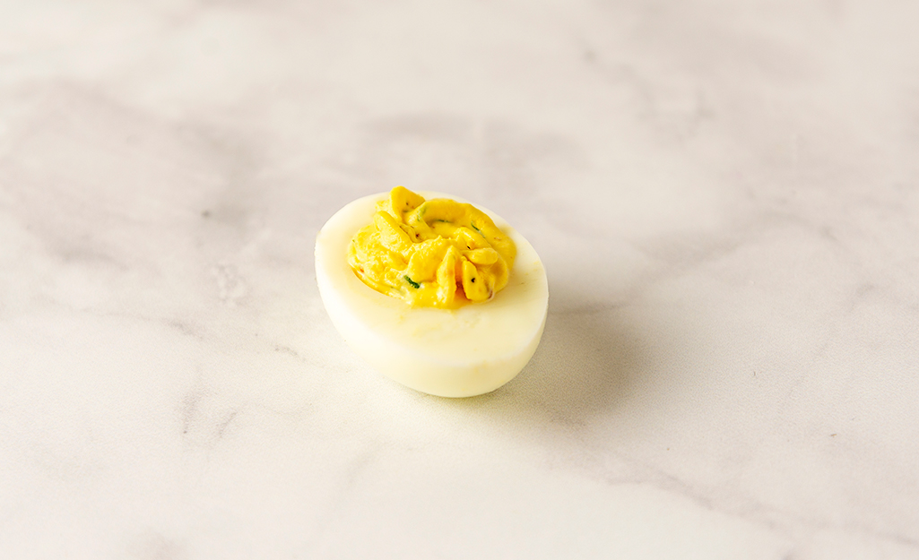 A single deviled egg on a table. A single deviled egg on a table.