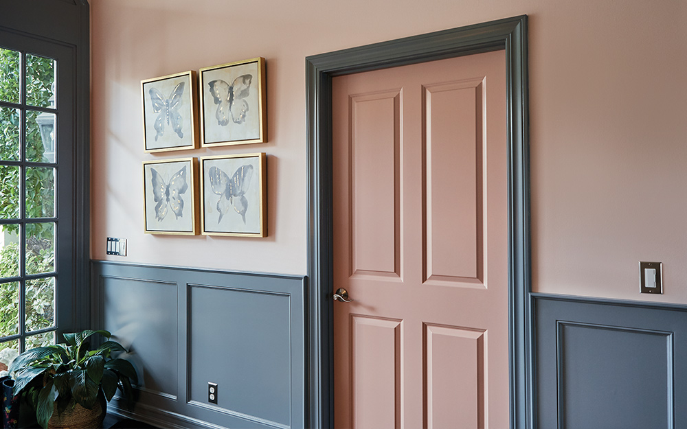 A hallway with finished wainscoting painted a deep shade of green. 