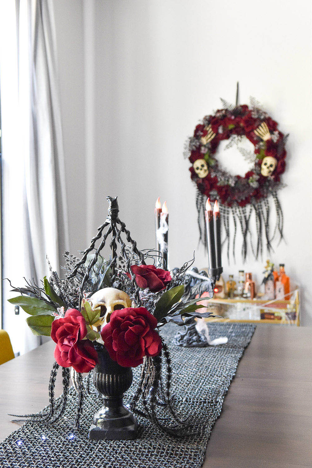 A Halloween dining room with a table runner and skull centerpiece.