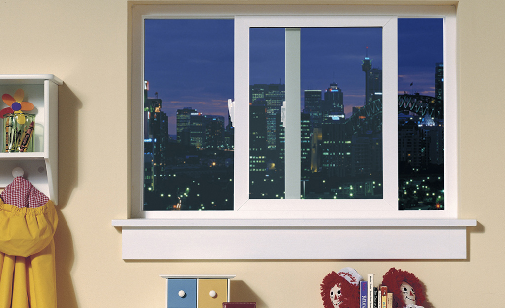 A sliding egress window in a child's room has a view of a city skyline.