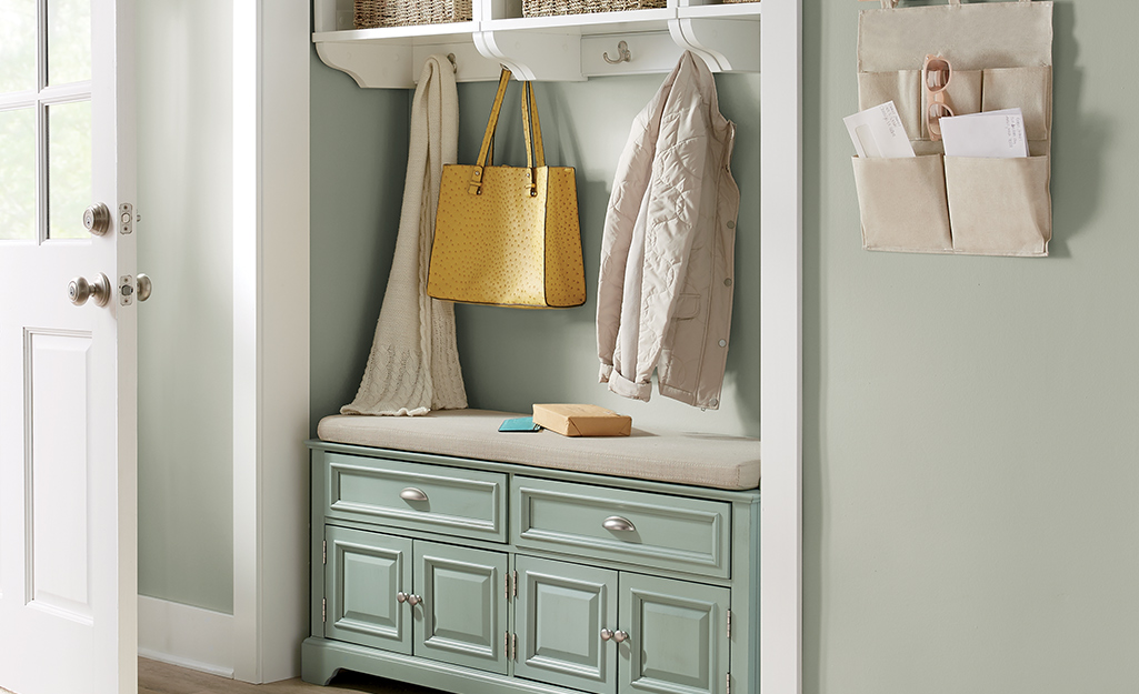 Hall tree with green drawers and white shelves.