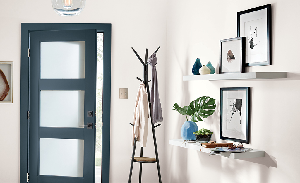 Small entryway with coat rock and wall shelves.