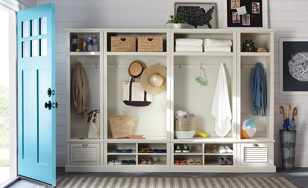 A wall length white hall tree with cubbies, hooks and shoe shelves.