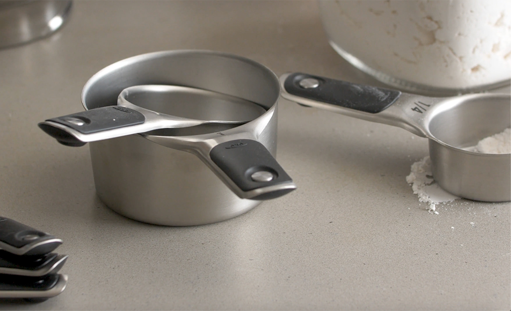 Several metal measuring cups sitting on a table