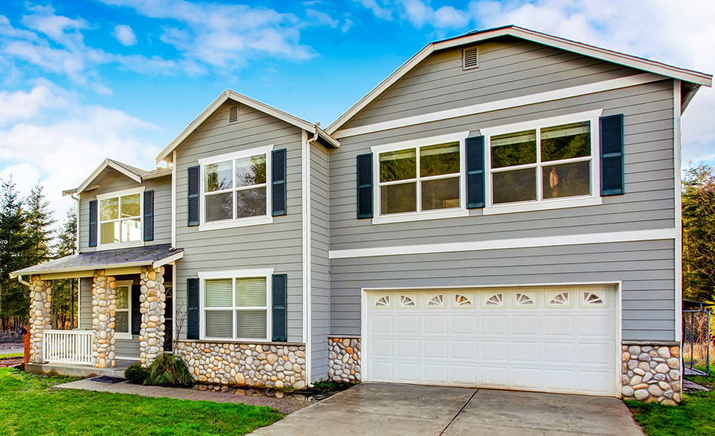 Pale gray exterior paint complements the stonework at the base of a house.