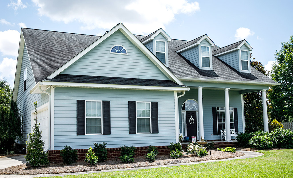 Black shutters complement the ocean blue exterior of a house.