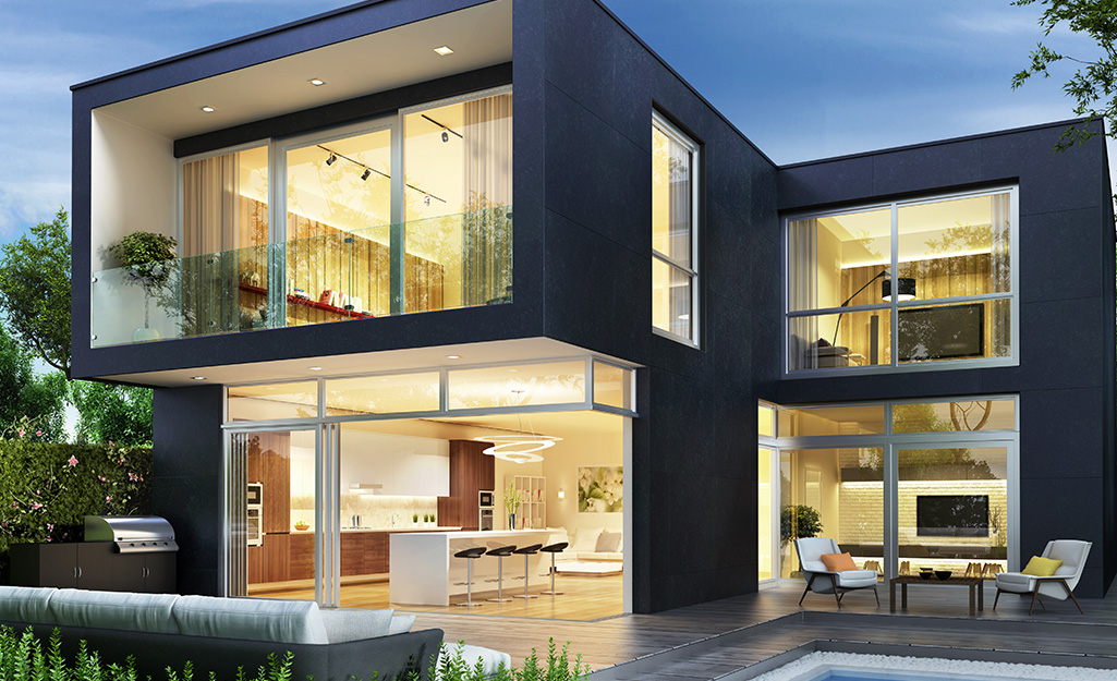 Black exterior paint emphasizes the large windows of a contemporary house.