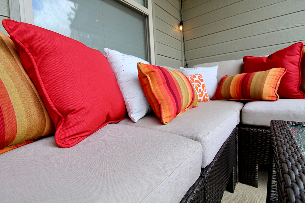 An outdoor sectional decorated with throw pillows in bright colors.