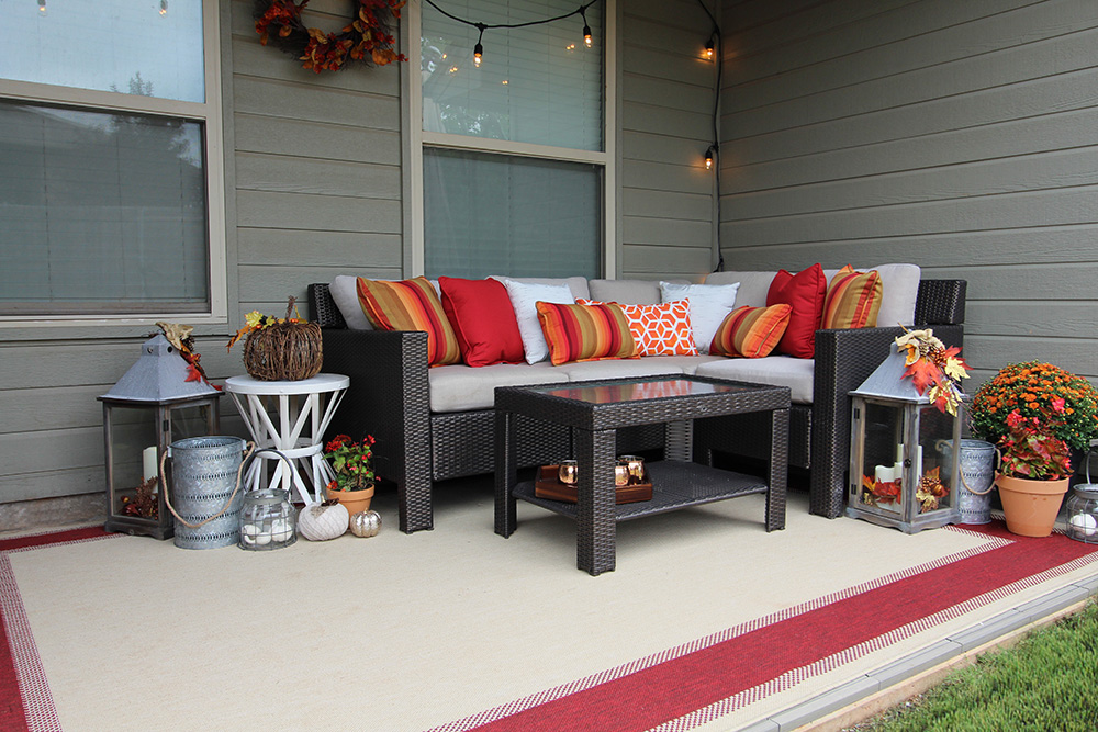 A Fall patio with an outdoor rug, sectional, and table.