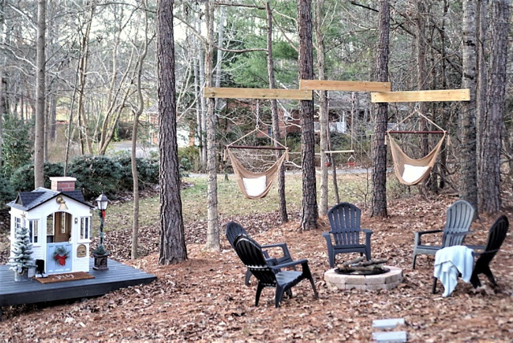 A shot of the backyard with chairs around a fire pit