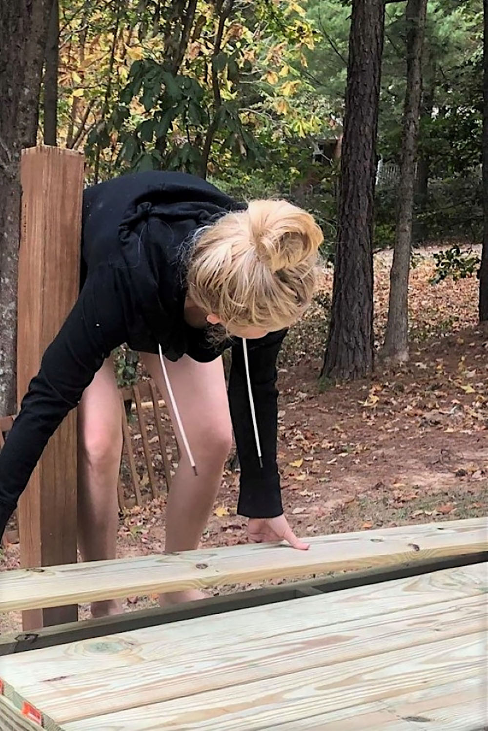 A person laying deck wood