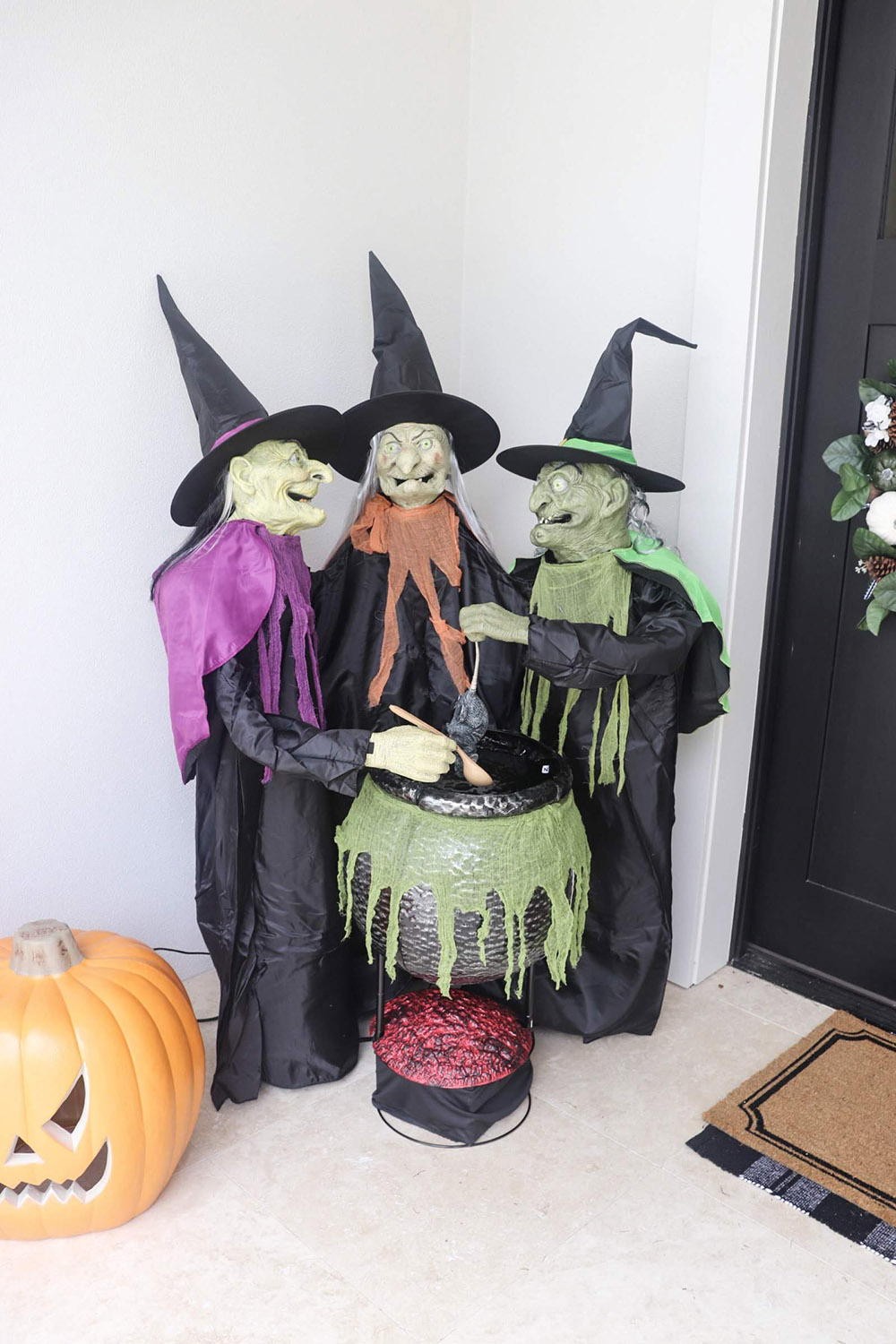 A trio of witches stirring a cauldron on a porch.
