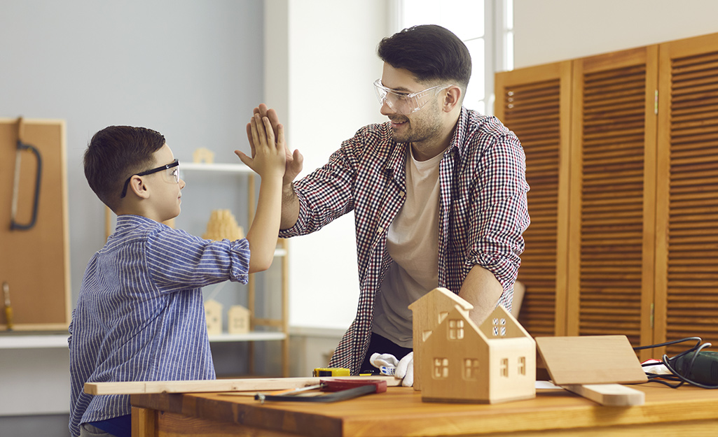 Father and son building a birdhouse together.