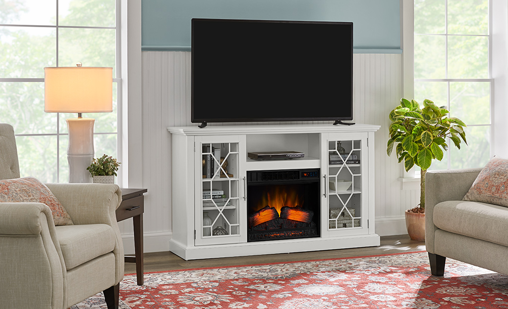 Electric fireplace in a media center with a TV on top.