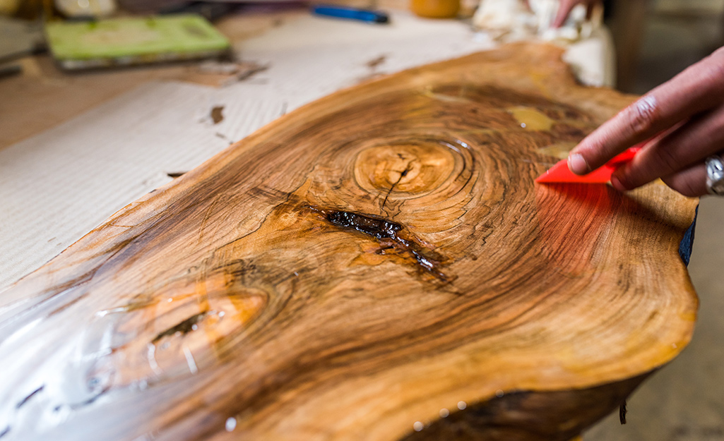 A person applies food-safe finish to a wooden piece.