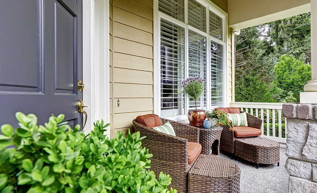 Comfortable patio furniture sits on a front porch.