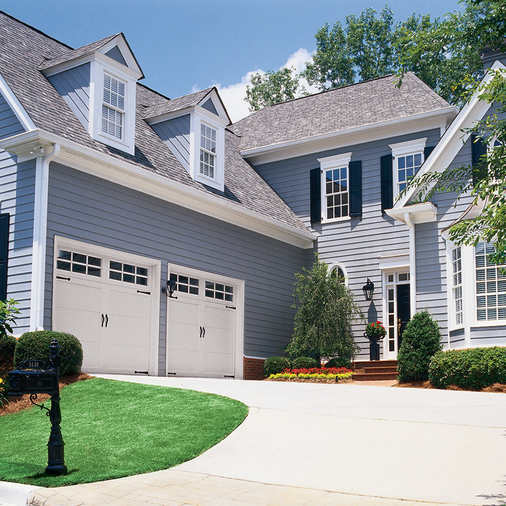 A home with garage doors at the end of the driveway.