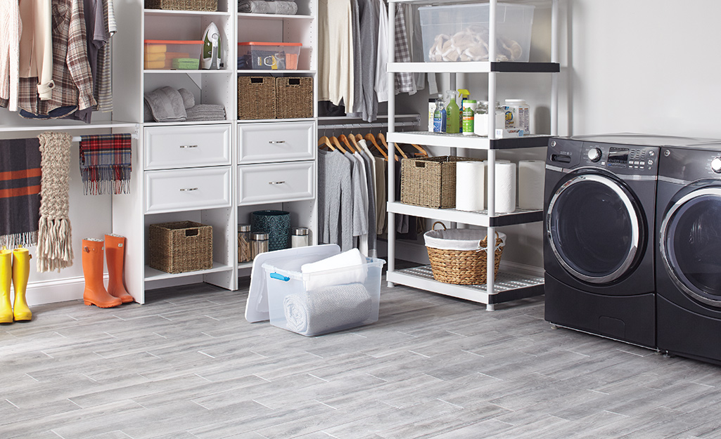 Porcelain tiles with a gray, wood-like appearance cover a garage floor.